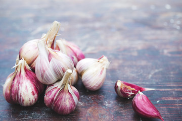 Fresh garlic crop on old wooden table, close-up