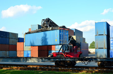 Shipping container loading by richtracker on the freight rail car at logistic warehouse port. Ocean...