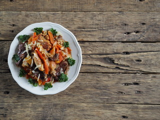 rabbit stew with vegetables on an ancient rustic wooden table