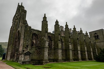 Obraz premium Ruin of the roofless gothic Holyrood Abbey near the Holyrood Palace, the official Scottish royal residence in cloudy weather