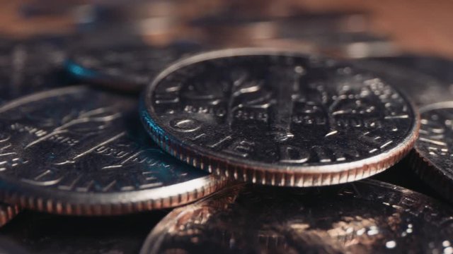Pile of shiny American dime coins, panning shot