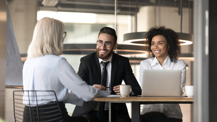 Smiling multiracial employers impressed by female applicant at interview