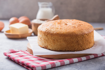 Homemade  Soft and lite delicious sponge cake with ingredients: eggs flour milk on stone concrete table. Bakery background concept.