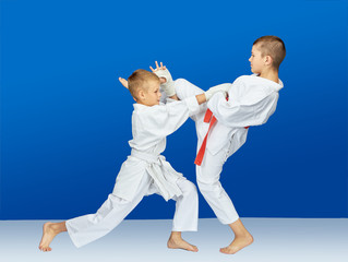 On a blue background athletes beat karate blows