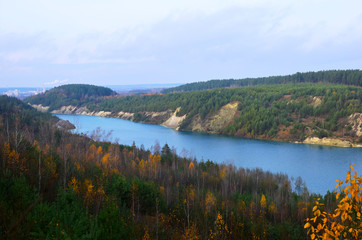 Obraz premium Artificial lake was is formed after the extraction of chalk in an industrial quarry at Krasnoselsky village in the Belarus. Water in open pit between the mountains. Belarusian Maldives
