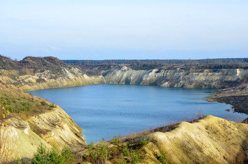 Artificial lake was is formed after the extraction of chalk in an industrial quarry at Krasnoselsky village in the Belarus. Water in open pit between the mountains. Belarusian Maldives