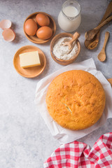 Homemade  Soft and lite delicious sponge cake with ingredients: eggs flour milk on stone concrete table. Bakery background concept.