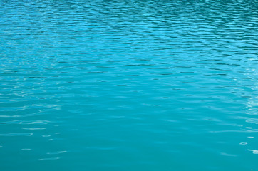 Turquoise clear ocean water background in summer tropical season. Transparent sea water texture with sunny reflections. Travel in paradise