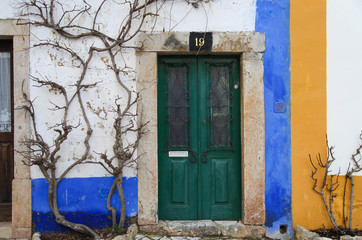 Fototapeta na wymiar Bright green front door in the Portuguese house. Obidos.