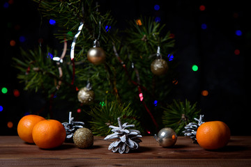 Fototapeta na wymiar Christmas, decoration on a wooden table. Christmas tangerines, cones and golden Christmas balls.