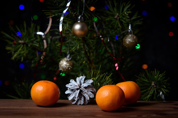 Christmas, decoration on a wooden table. Christmas tangerines, cones and golden Christmas balls.