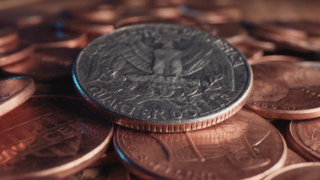 An American quarter coin in a pile of pennies