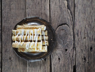 pancakes with sour cream and jam on a metal plate on an ancient wooden table