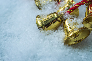gold christmas bells on white snow background