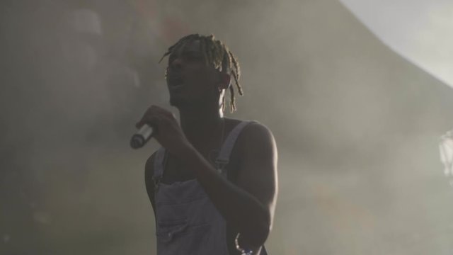 Black rapper in overalls on stage