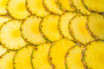 Pineapple juicy yellow slices background. Top view.