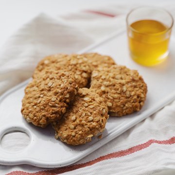 oatmeal cookies, honey and nuts on a white towel. Rustic style. White background. High key in food pictures