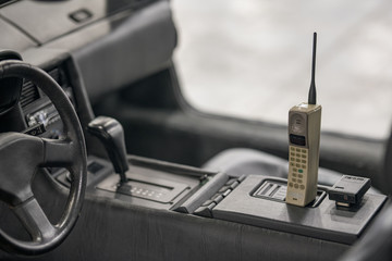 Old antique cellular phone in an old car