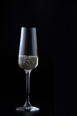 Glass with sparkling champagne at black background, magazine and commercial photo with space for text or design, festive and celebrating food and drink photography