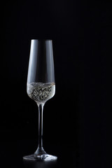 Glass with sparkling champagne at black background, magazine and commercial photo with space for text or design, festive and celebrating food and drink photography