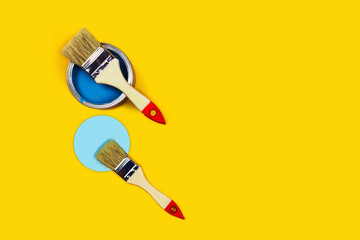 Colored background with paint jar and brushes.