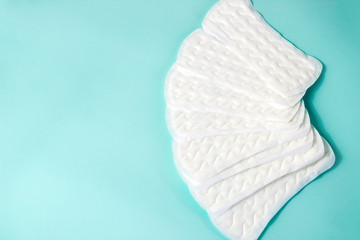 flat lay of feminine hygiene items. Details for critical women's days on a turquoise background. Gaskets for women, health