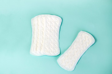 flat lay of feminine hygiene items. Details for critical women's days on a turquoise background. Gaskets for women, health