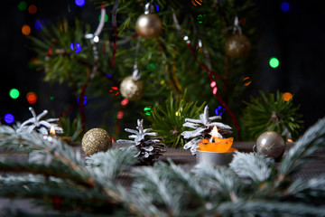 Fototapeta na wymiar Christmas, decoration on a wooden table. Christmas pine cones and golden Christmas balls. Burning candle