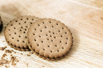 Crispy chocolate chip cookie with holes on a wooden board. Filled Round Cookies