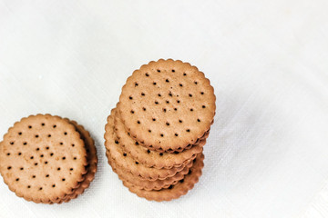 Crispy chocolate chip cookie with holes on the table. Filled Round Cookies