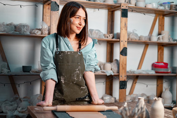 Young Beautiful Woman Dreaming About Her Prospective Ceramics Dishware She Will Create at Master Class.