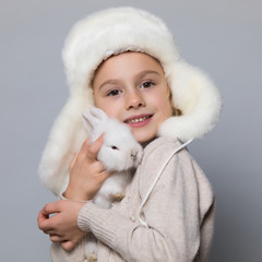 happy little girl with adorable rabbit at christmas time.