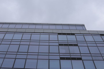 Abstract business modern city urban futuristic architecture background, motion blur, reflection in glass of high rise skyscraper facade, toned blue picture with bokeh. Real estate concept
