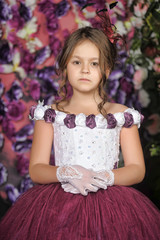 Girl in a purple dress on a floral background