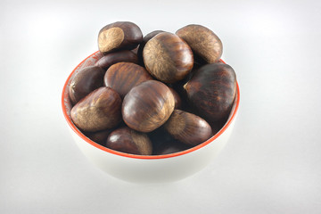 Chestnuts close up. Raw Chestnuts. Fresh sweet chestnuts in a bowl. Food background.