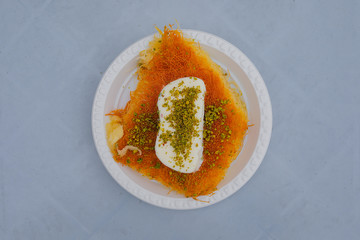 Middle-Eastern Delicious traditional dessert kadayif kunefe with pistachios. Ice cream on top. Turkish dessert kadayif kunefe.
