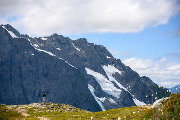Fototapeta premium Hiker Stands At The Edge of Ridge