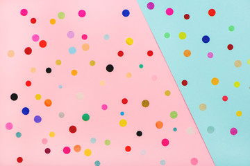 Colorful confetti on pink and blue background.