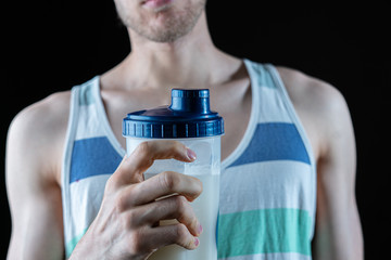 male skinny sport man holding a shaker while workout