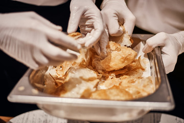Closeup of professional chef plating dish in restaurant kitchen..