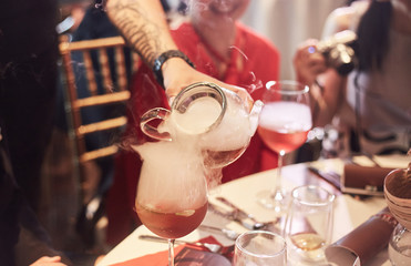 Man pouring hot tea into glassware, Focus at glass pot
