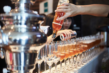 Barman pouring fresh alcoholic drink into the glasses, Selective.
