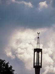 Mosque tower against cloudy sky