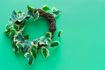 Wooden crown with ivy on blue background. Copy space, Top view.