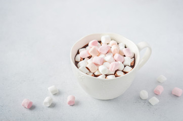 Cup of hot chocolate with marshmallows on a gray concrete background. 
