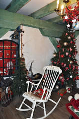 Christmas scene with a Christmas tree, gifts, toys, garlands and a bench, on the background of a wall decorated with wood.