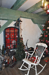 Christmas scene with a Christmas tree, gifts, toys, garlands and a bench, on the background of a wall decorated with wood.