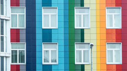 Modern bright rainbow facade of a kindergarten. Multicolor wall of a public building. Positive vibrant architecture.