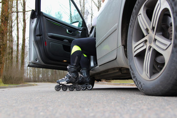 Men's legs on roller skates in a car. The choice of a healthy lifestyle. Car rejection, rejection of exhaust gases