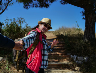 Naklejka premium Girl tourist calls to follow her along the trail